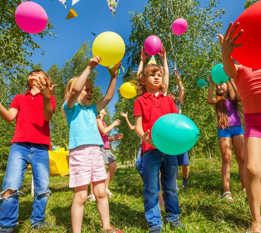 Children playing with balloons at a festival in the park