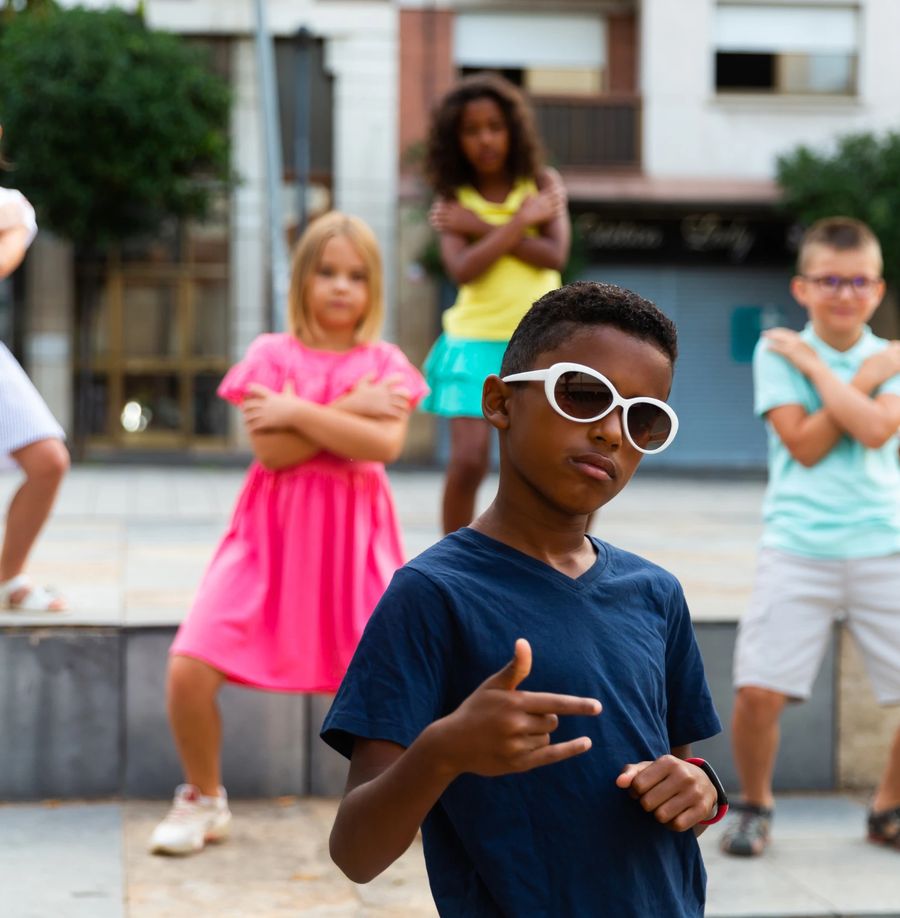 A group of children dancing together on a city square